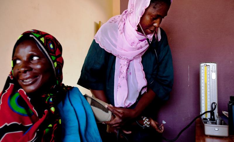 health worker takes a woman's blood pressure in Mali
