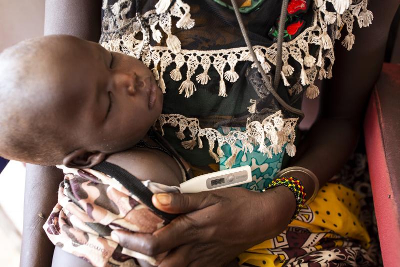 A baby gets her temperature taken