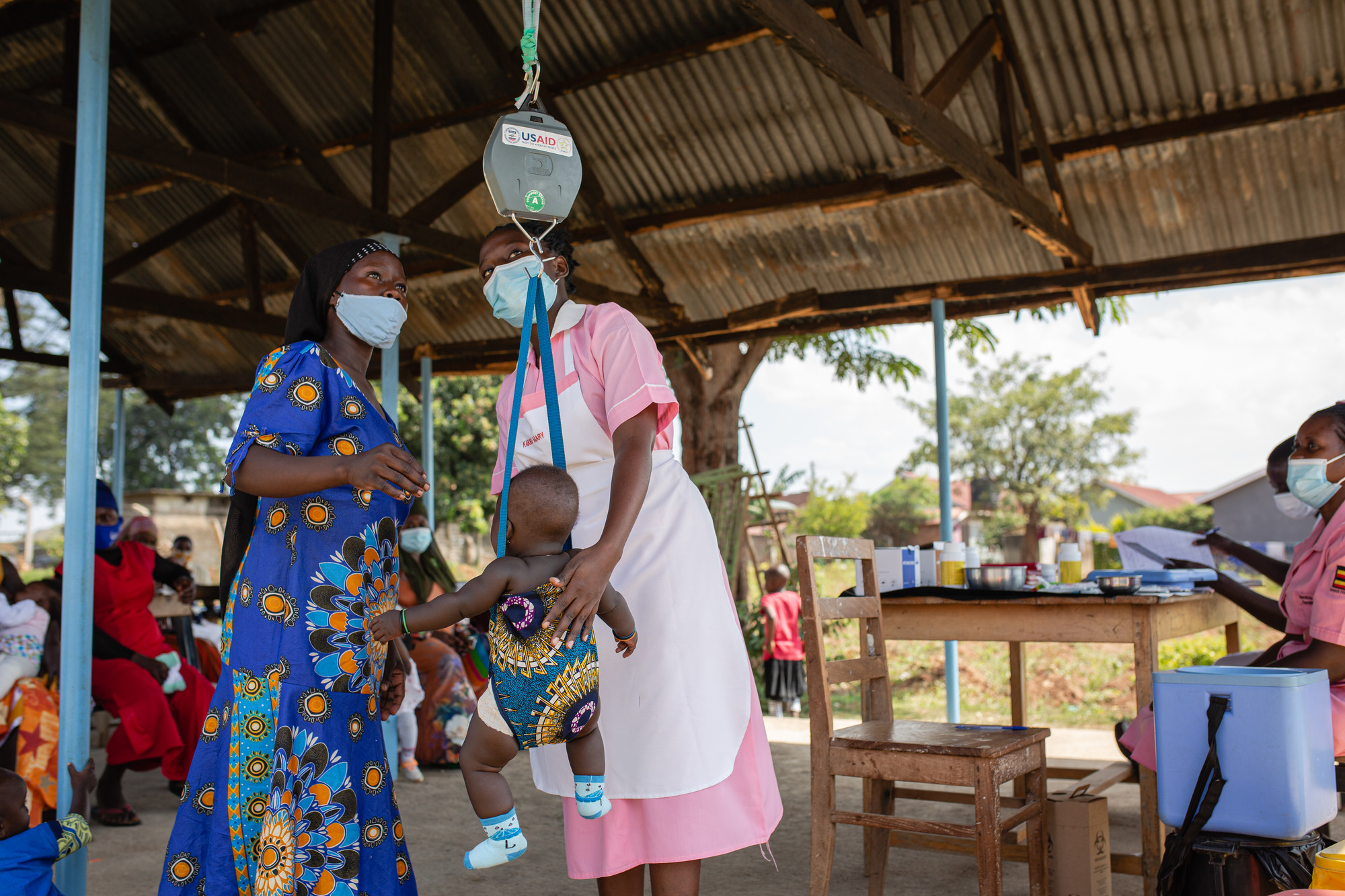 Namuwaya Nsabu weighs her 9 month old baby before receiving immunization services at Nakaloke Health Center III in Mbale, Uganda. Photo by Esther Ruth Mbabazi for IntraHealth International.