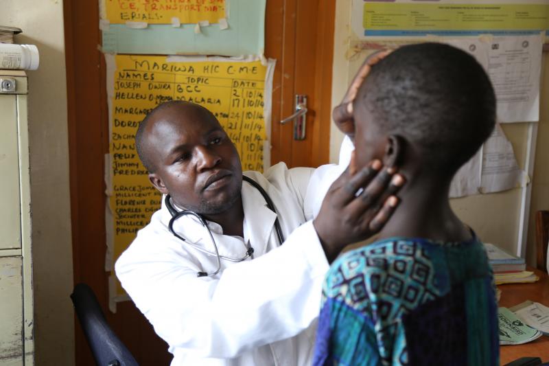 Photo: Joseph Otieno Owira, a clinical officer at Mariwa Health Center in Migori County, Kenya, cares for a young boy. Photo by Wycliffe Omanya for IntraHealth International.