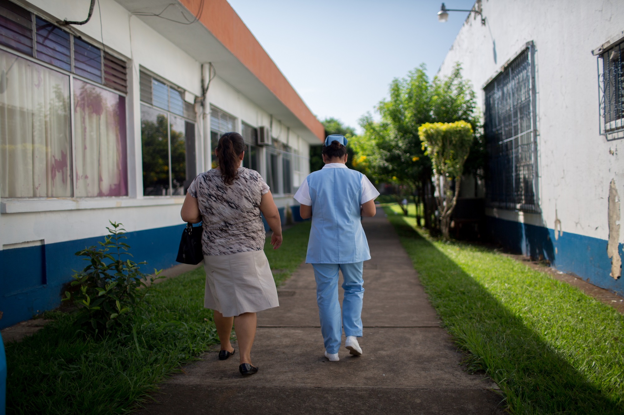A nurse takes escorts a client to health services in Guatemala. Photo by Anna Watts for IntraHealth International.