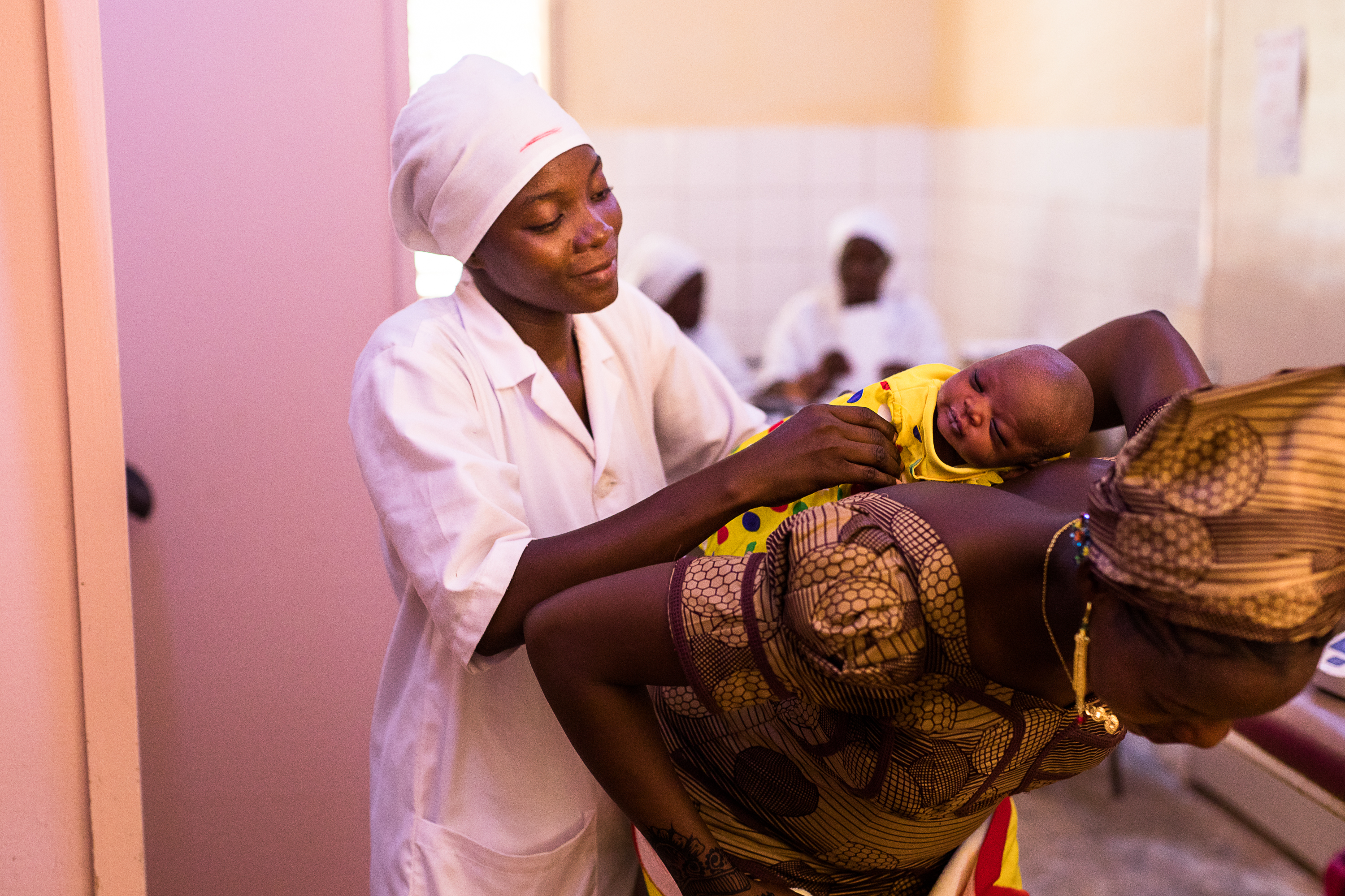 A health worker helps a mother and her baby at a health facility in Ouagadougou in 2017. Photo by Trevor Snapp for IntraHealth International.